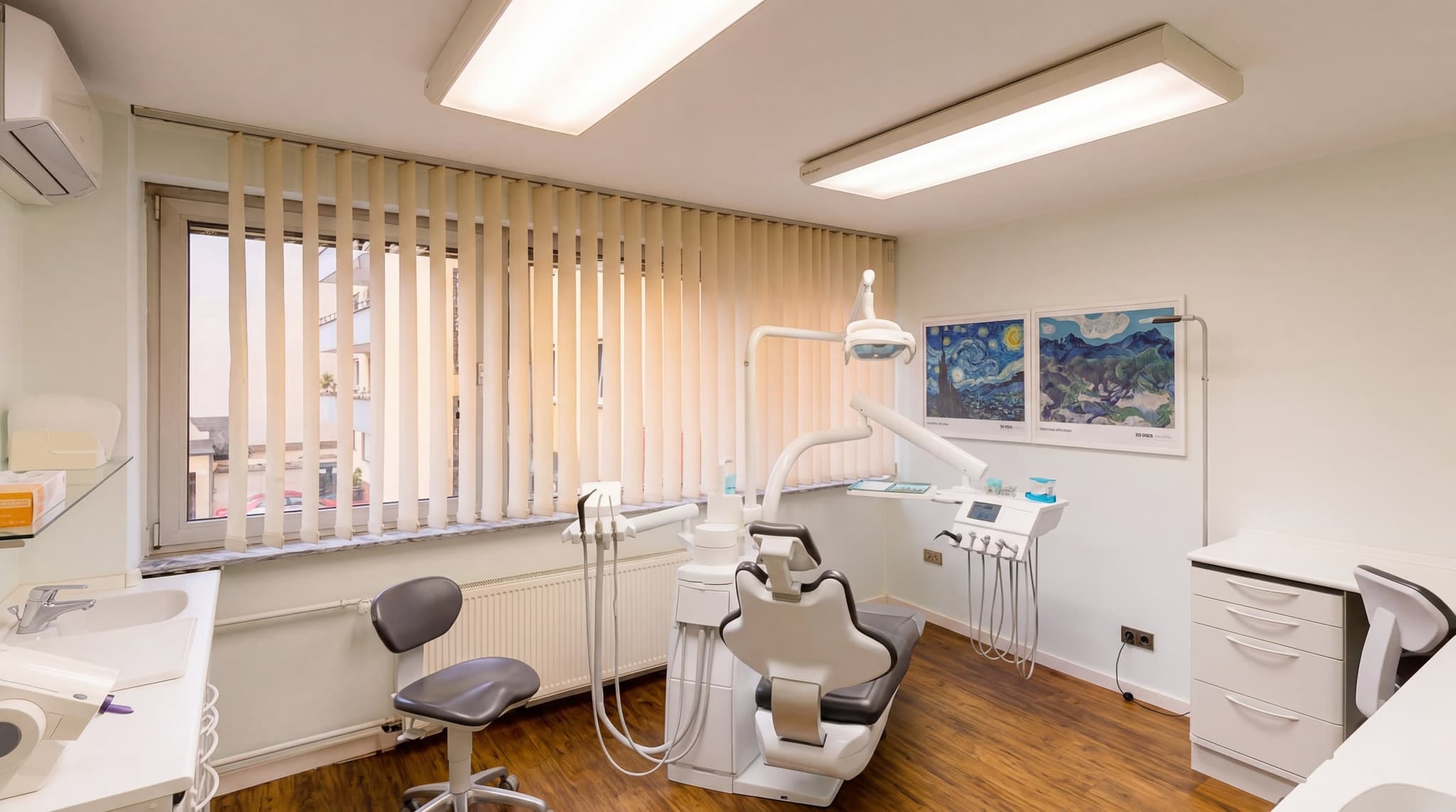 Moderner Behandlungsraum mit Kunstwerken — Praxis Dr. Hakimi